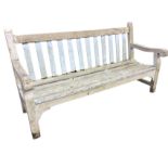 A heavy teak 6ft garden bench with slatted back and seat having shaped arms on rectangular legs &