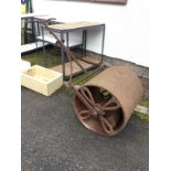 A large cast iron garden roller, the handle with scrolled mounts above a weighted drum. (63in)