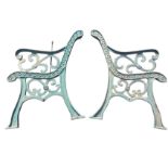 A pair of cast iron bench ends of scrolled design on channelled sabre legs. (2)