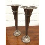 A pair of hallmarked silver trumpet vases with waved flared rims above tapering bodies on circular