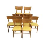 A set of twelve 60s beech chairs with curved back rails having padded vinyl upholstered seats,