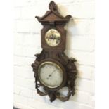 A Victorian carved oak barometer, the silvered dial by Wood & Co of York framed by winged gryphons