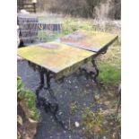A Victorian garden table with later two section iron top, the base with pierced scrolled ends joined
