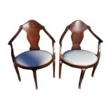 A pair of mahogany arm chairs with wide splats to backs above oval upholstered seats, raised on
