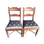 A pair of Regency style mahogany dining chairs the back rails with tablets below fluting, above