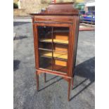 An Edwardian mahogany music cabinet with shaped upstand above a frieze inlaid with chequered