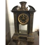 A Victorian polished slate mantle clock, the architectural style breakfront case with foliate