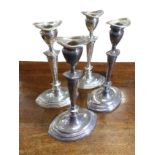 A set of four Georgian style oval silver candlesticks with detachable sconces, on moulded bases -