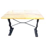 A rectangular Victorian table, the beech top on cast iron supports with pierced decoration, raised