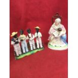 A nineteenth porcelain group of four minstrel boys with their instruments standing by fence on