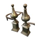 A pair of nineteenth century chenets with octagonal tapering brass finials on moulded column