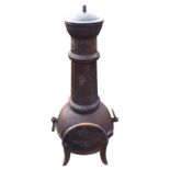 An iron chiminea, the bulbous stove with ring handles beneath tapering chimney with domed cover,