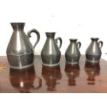 A graduated set of four Irish pewter tavern jugs with applied scrolled handles to tapering