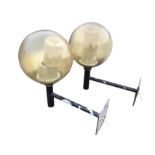 A pair of 1970s outside lights with 25in globes on tubular supports, mounted with square wallplates.