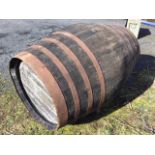 A large oak whiskey barrel, the staithes mounted with eight riveted metal strap bands. (51in)