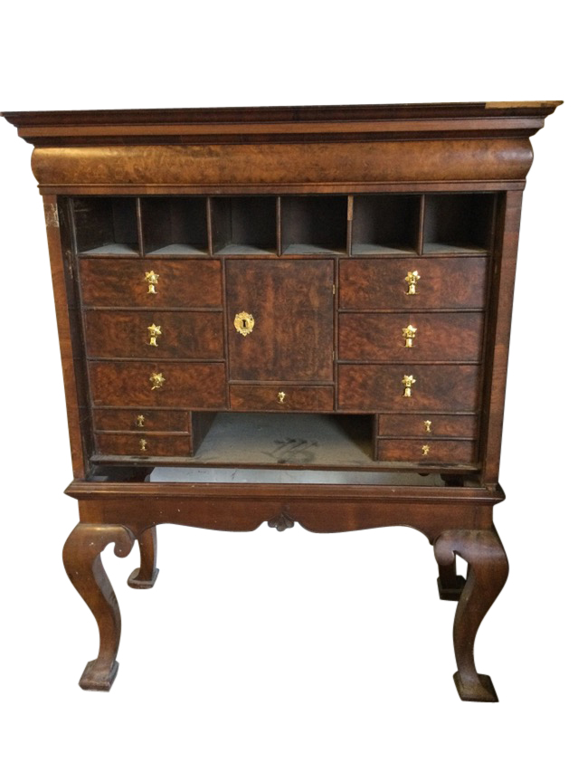 A walnut cabinet on stand having long cushion moulded frieze drawer above pigeonholes and drawers