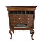 A walnut cabinet on stand having long cushion moulded frieze drawer above pigeonholes and drawers