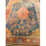 A large Turkey carpet, the central blue field woven with oval orange scalloped medallion having