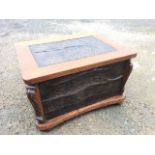 An oak coal box with embossed art nouveau copper panels, having carved corners on shaped plinth with