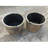 A pair of oak garden barrel tubs, each with three riveted iron strap bands. (26in x 16in) (2)