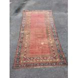 An antique Indian runner, the orange field woven with rows of floral paisley style motifs framed