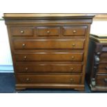 A reproduction mahogany bedroom chest with cushion moulded top above three short drawers and four