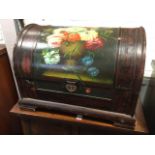 A domed top box with handpainted floral panel to hinged lid, having embossed escutcheon and