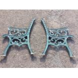 A pair of cast iron garden bench ends, with scrolled decoration to channelled frames, the scrolled