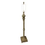 A patinated metal standard lamp with column on square moulded base, having leaf and scrolled pierced