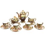 A Noritake coffee set decorated with water landscape vignettes in gilt scrolled panels on brown