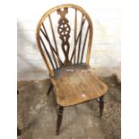 A single antique elm wheelback chair, the hooped back on spindles framing pierced splat, the solid