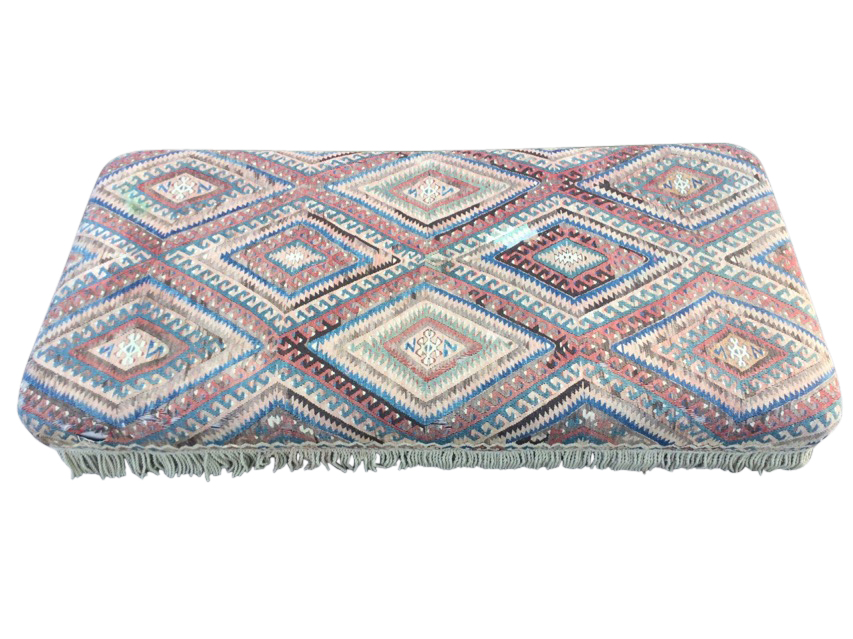 A large kilim covered ottoman stool, the antique weaving with hooked lozenge panels above a