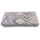 A large kilim covered ottoman stool, the antique weaving with hooked lozenge panels above a