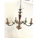 A hanging chandelier supported by chain having red enamelled column with brass mounts, supporting