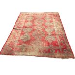 A Turkey carpet woven in the traditional palette of blue/green medallions on red ground, the