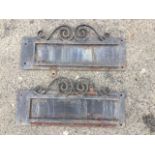 A pair of rectangular wrought iron wall signs, with scrolled decoration to frames for sliding in