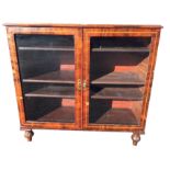 A glazed mahogany bookcase with oval shell paterae to moulded top above boxwood strung doors