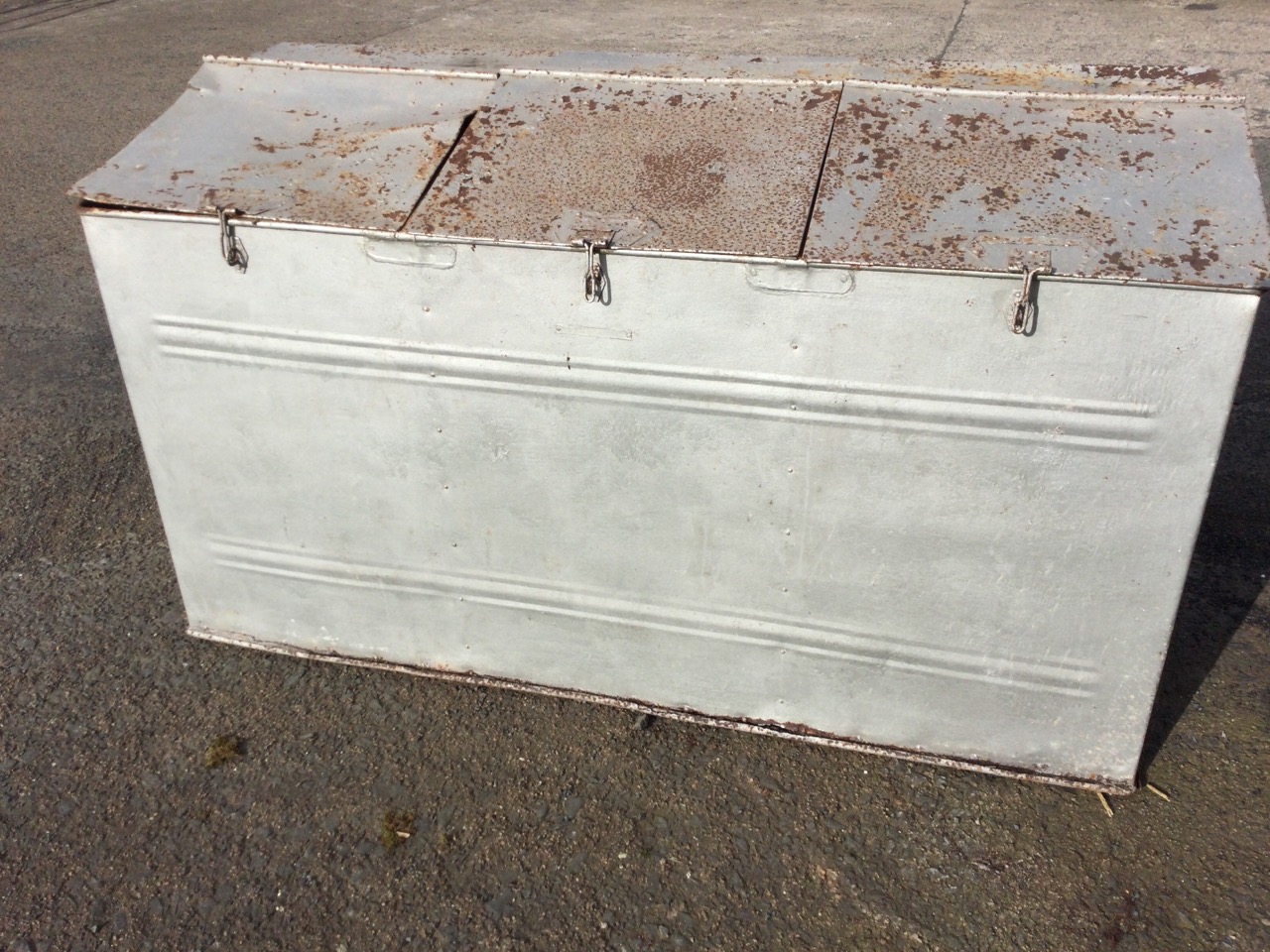 A galvanised metal feed bin with angled hinged lids, having three seperate compartments. (60in x