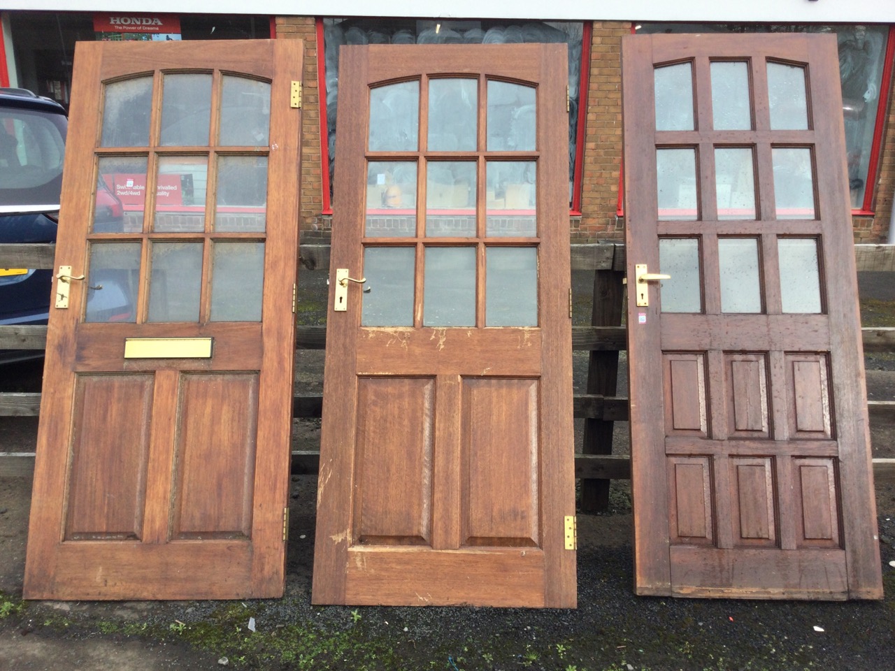Three glazed hardwood doors, each with nine panes and fielded panels, all mounted with brass 5-lever