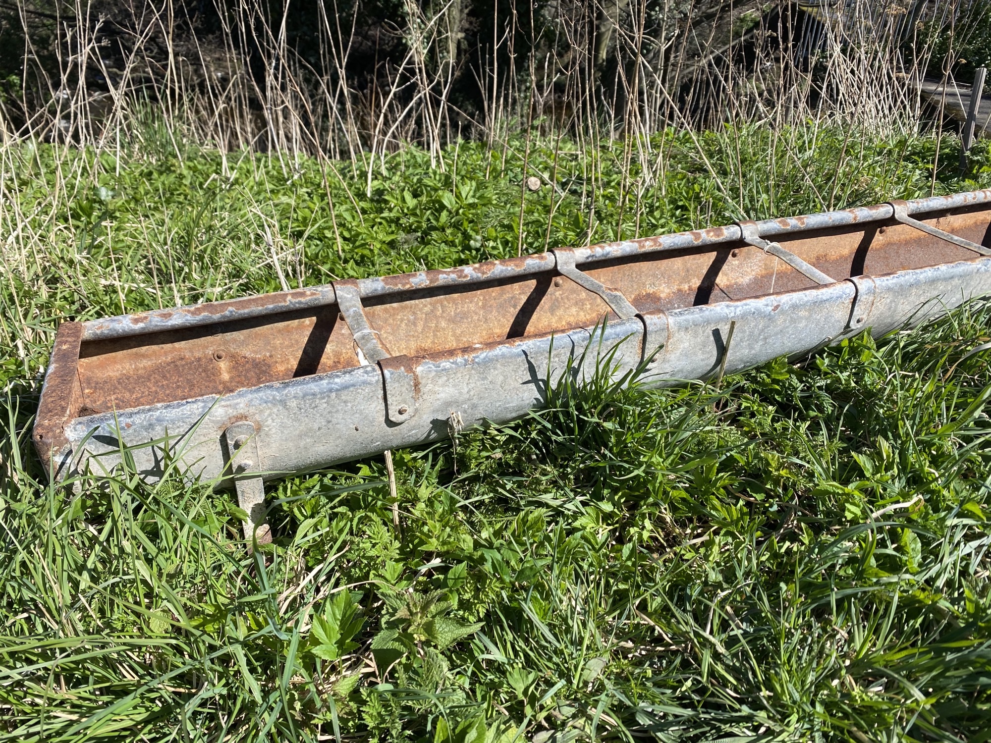 A 6ft rectangular galvanised feeding trough with tubular rim raised on bracket feet. (72in x 10in - Image 2 of 3