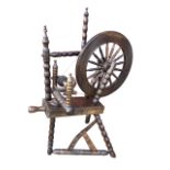 A Victorian oak spinning wheel on angled bobbin-turned legs, the treadle action driving spindled