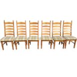 A set of six pine ladderback dining chairs with upholstered seats, raised on turned legs &