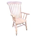 A beech slatback farmhouse armchair with shaped arms on spindles, the seat raised on turned legs and