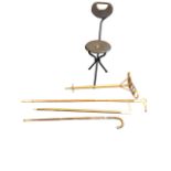 An Edwardian bamboo folding shooting stick with brass mounts; two staghorn handled hazel sticks; a