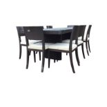 A contemporary rectangular dining table with eight chairs, the top with two draw leaves on column
