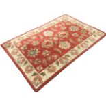 A contemporary oriental style Indian wool & cotton rug, the pink field woven with linked flowers and
