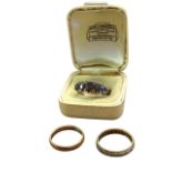 A Victorian 9ct gold ring set with graduated scrolled mount of five rubies; a 9ct gold wedding band;