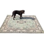An oriental style rug having pale green field woven with central floral medallion bordered by