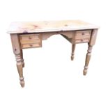 A reproduction pine kneehole dressing table or desk, the rectangular moulded rounded top above a