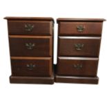 A pair of reproduction mahogany cabinets with moulded tops, each with three drawers mounted with